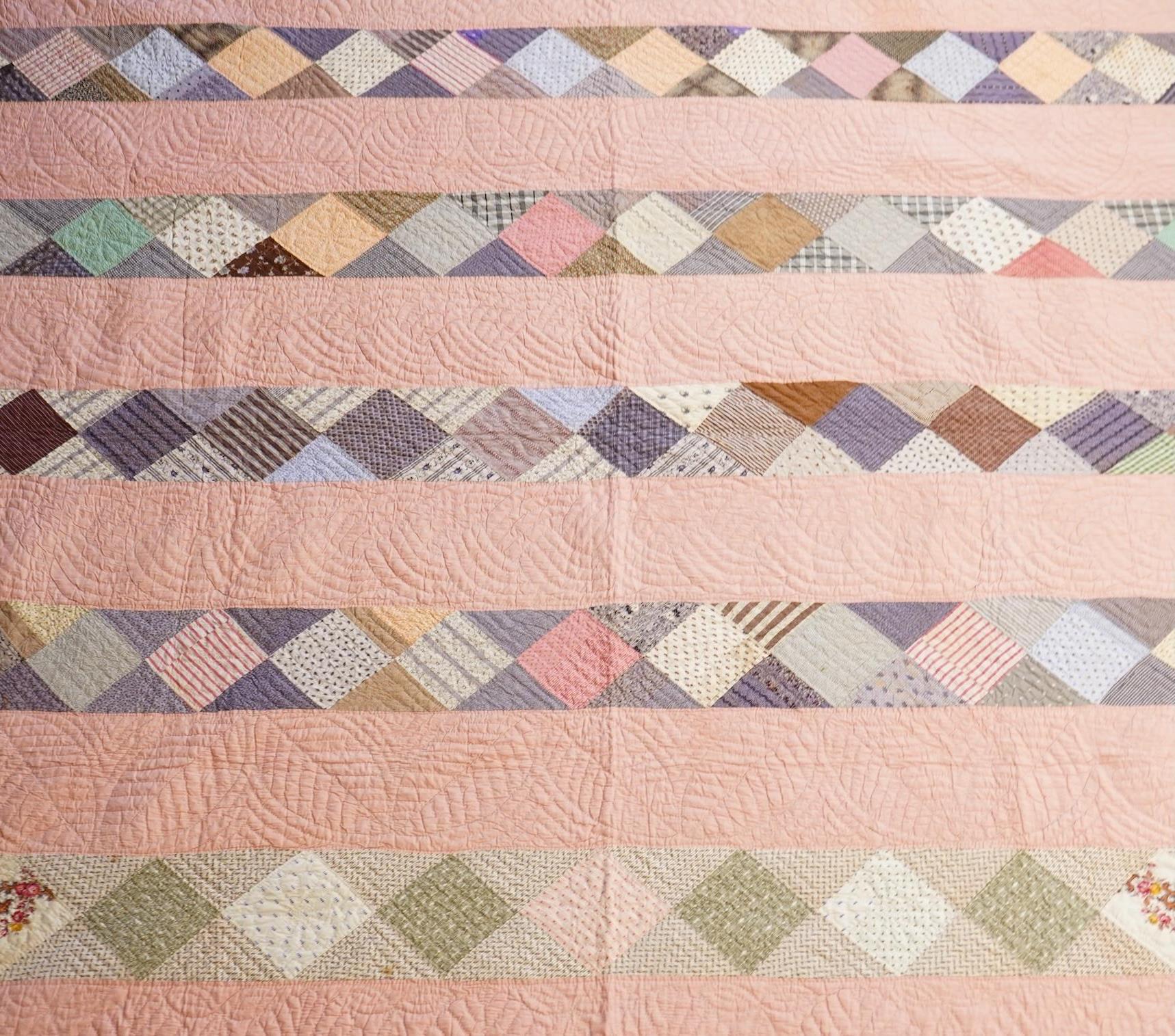A late 19th century English, possibly ‘North Country’ cotton, hand quilted bed cover. Worked in stripes, with alternate patch worked stripes of differing colour fabrics. Made from fashionable cotton fabrics of the era. R